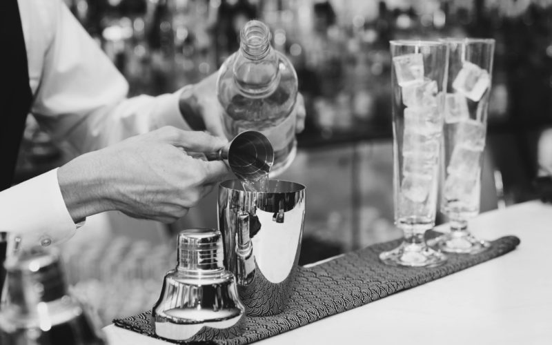 36749051 - bartender is pouring liquor in golden shaker, toned image